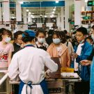 pepole in China wear face masks while waiting to be served food in market